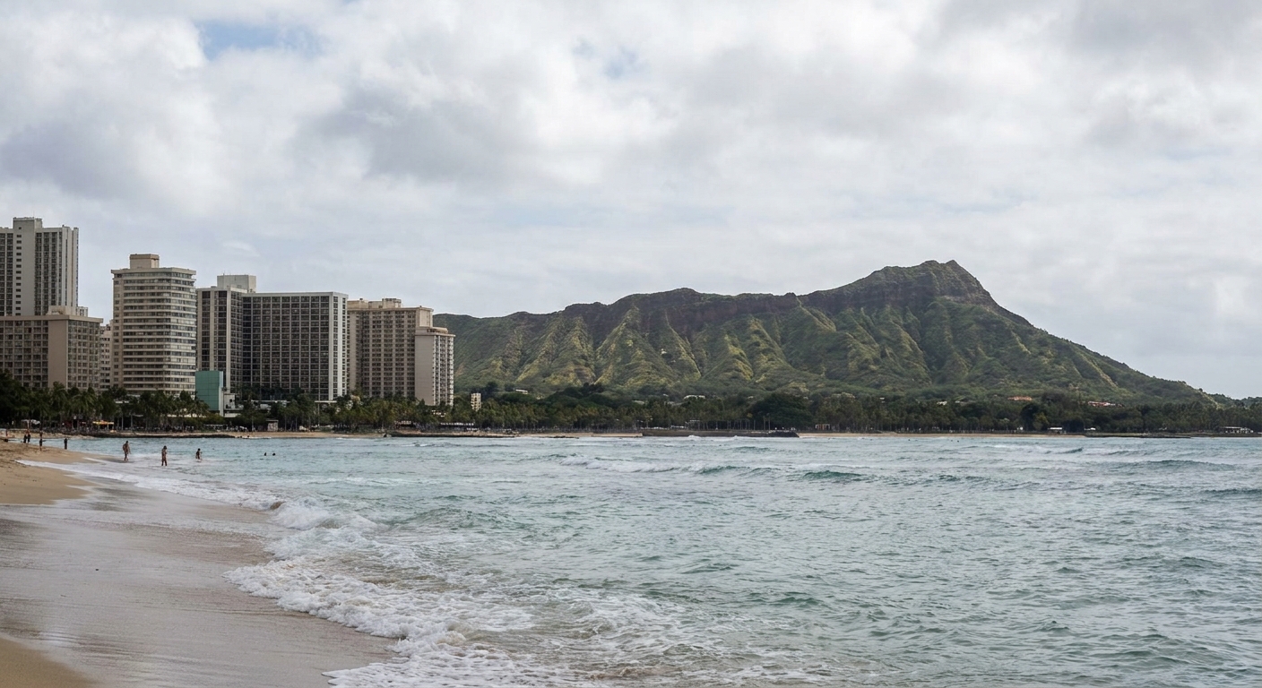 Waves rolling onto Waikiki Beach with Diamond Head crater in the background under a partly cloudy March sky