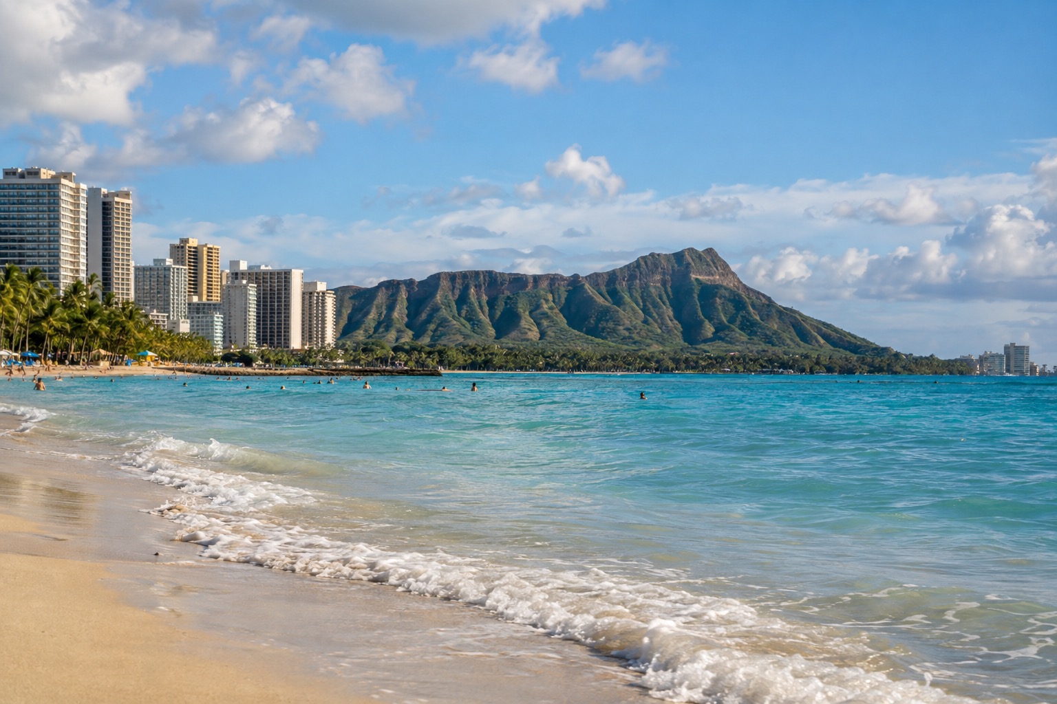 Waikiki Beach with the Diamond Head crater rim visible in the background under a partly cloudy sky