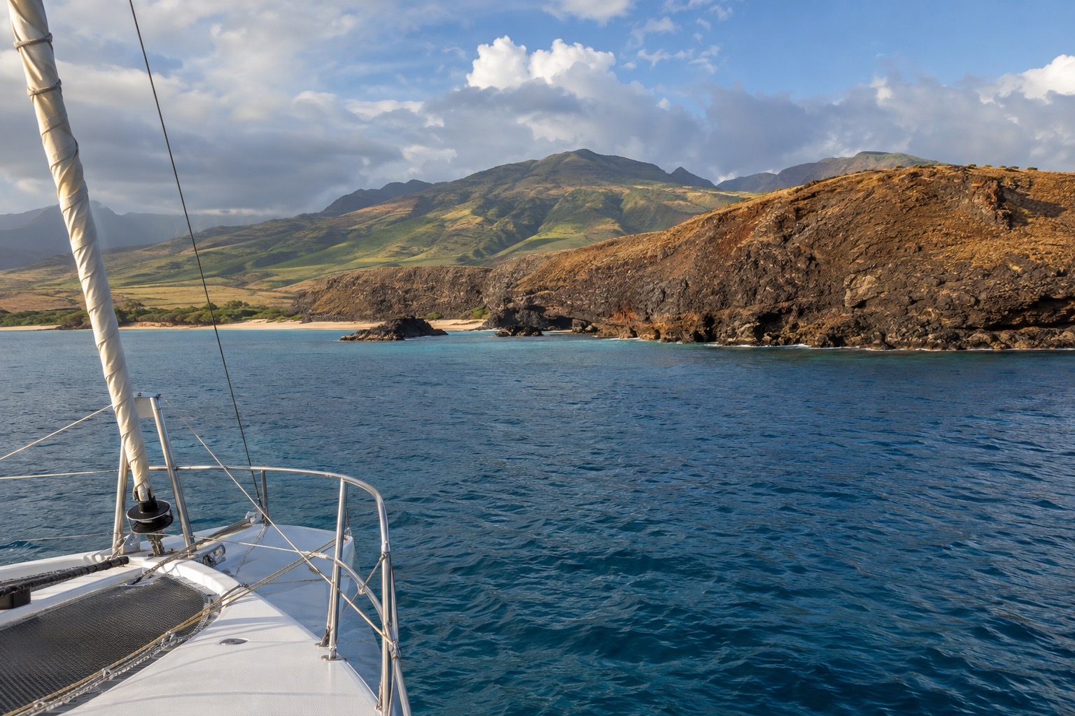 Boat anchored near a crescent-shaped volcanic crater rim offshore