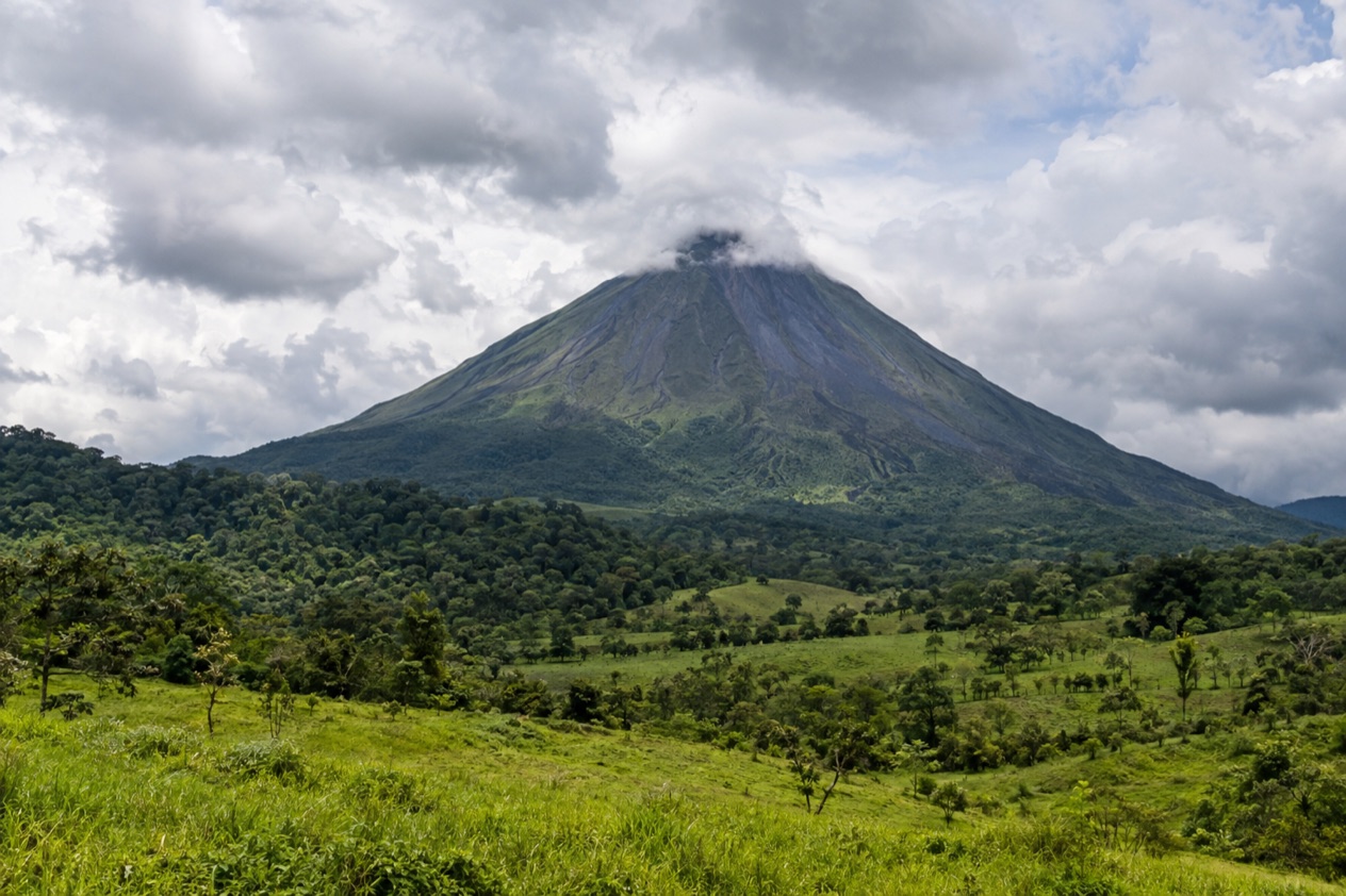 Arenal Volcano above the fields near La Fortuna in the rainiest months