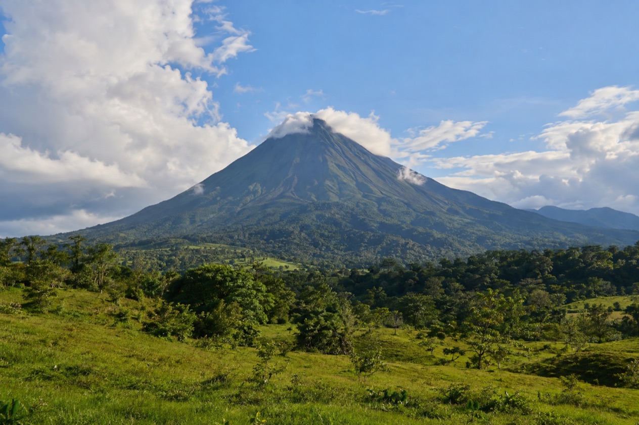 Arenal Volcano above the fields near La Fortuna in the green season
