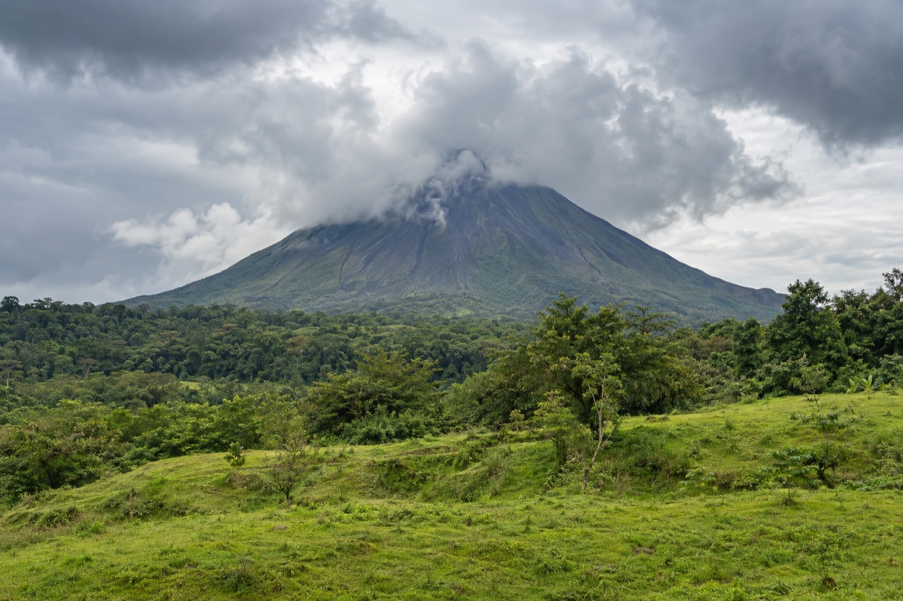 Arenal Volcano above the fields near La Fortuna in the rainiest months