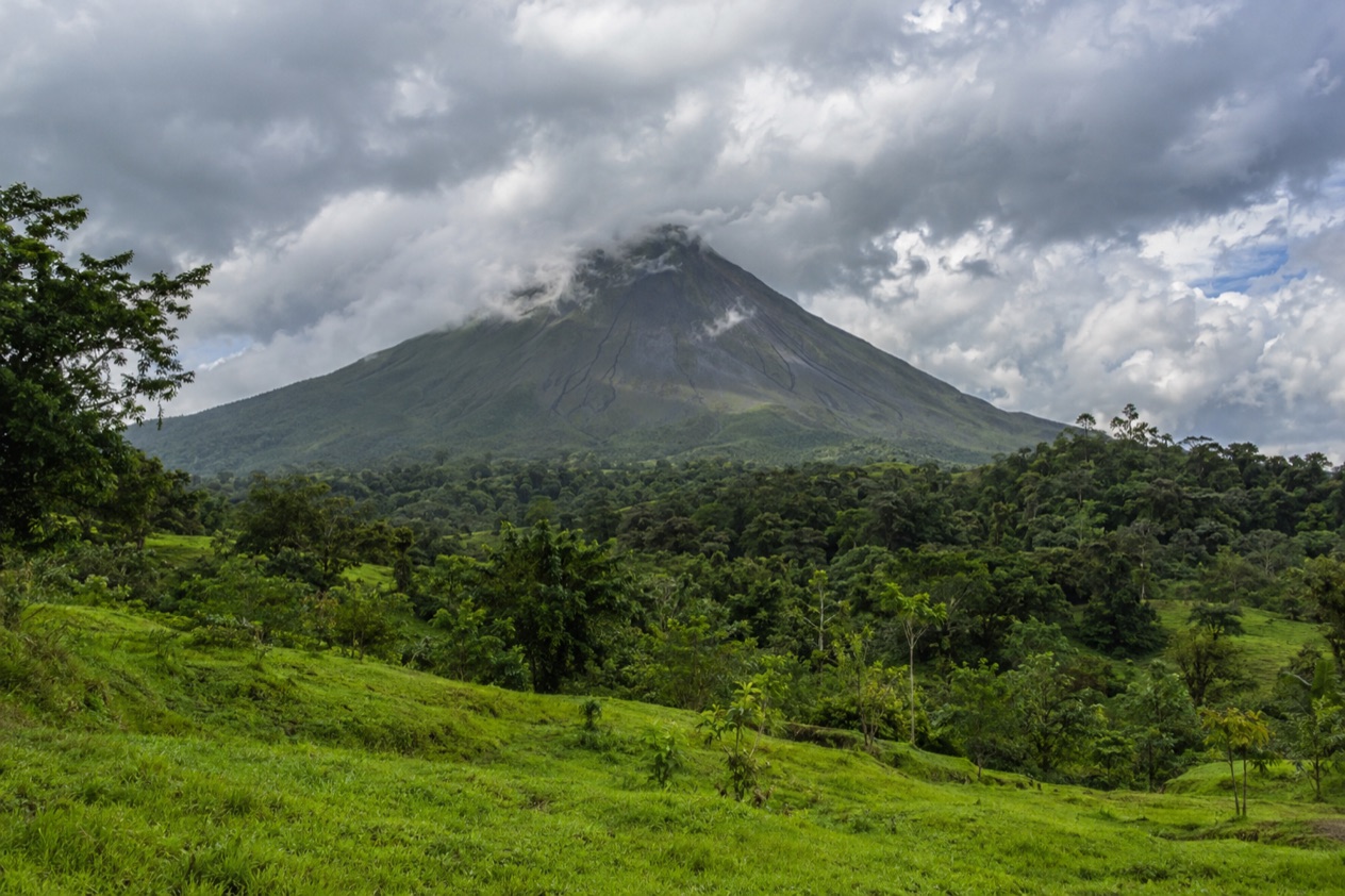 Arenal Volcano above the fields near La Fortuna in the rainiest months