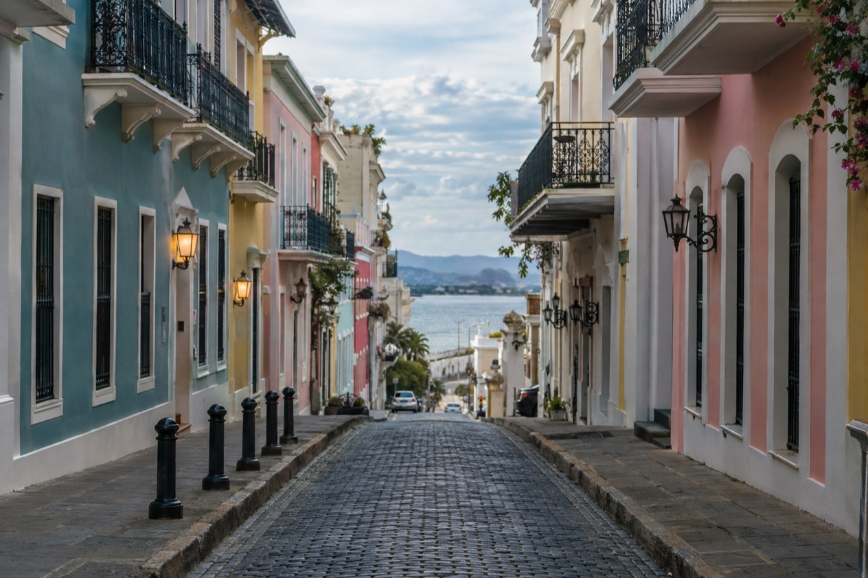 A cobblestone street in Old San Juan between pastel colonial houses