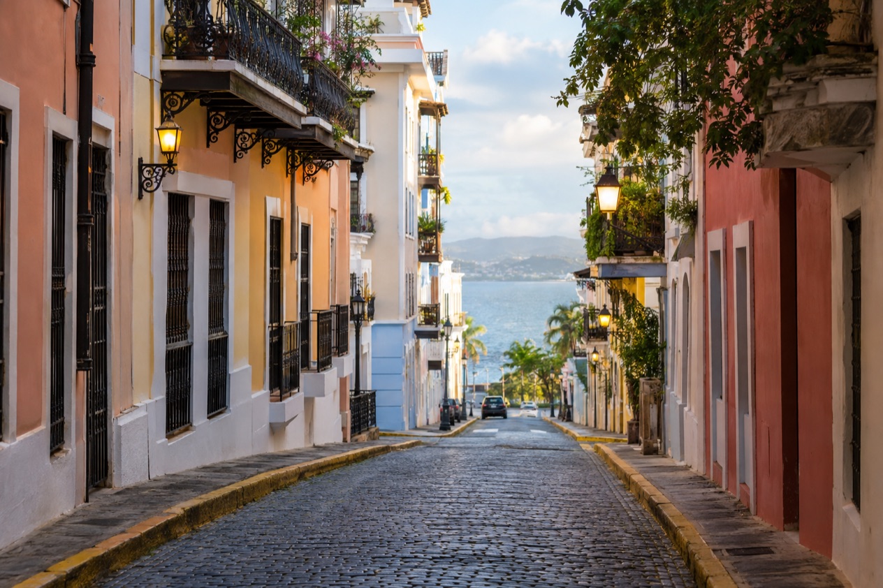 A cobblestone street in Old San Juan between pastel colonial houses