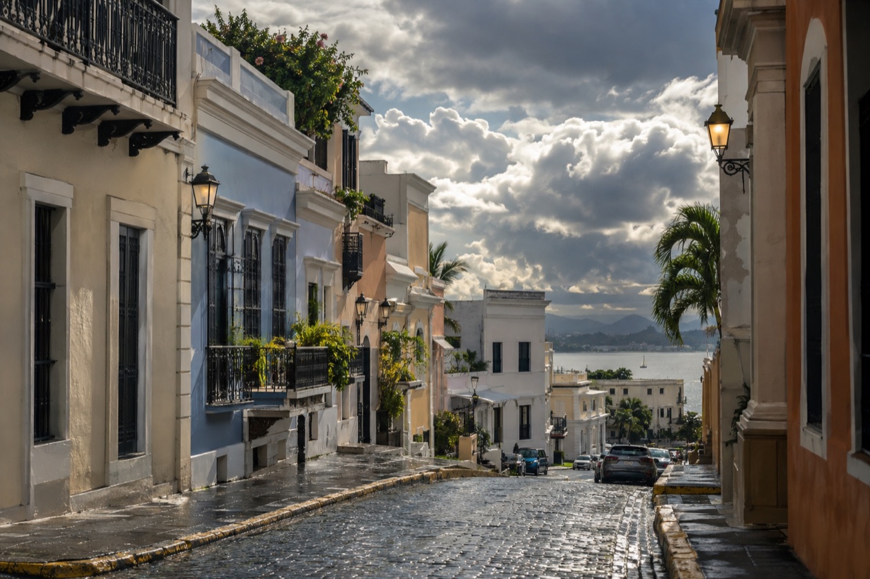 A cobblestone street in Old San Juan between pastel colonial houses in the wetter months